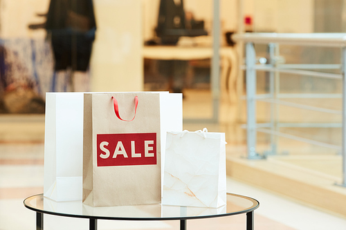 Image of paper shopping bags standing on the table after Christmas sale in the shopping mall