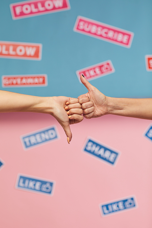 Close-up of hands showing like or dislike isolated on pink blue background