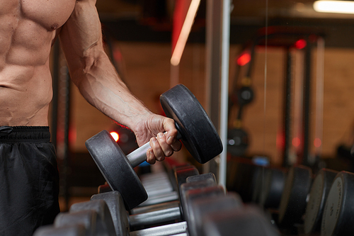 Close-up of muscle man lifting barbell while training in gym