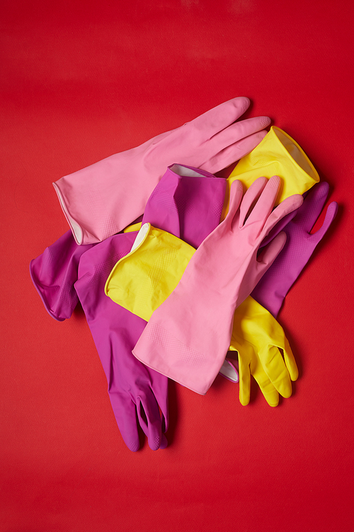 High angle view of colorful rubber gloves for cleaning isolated on red background