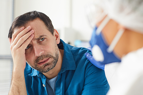 Upset mature man listening to the doctor's conclusion during his visit at hospital