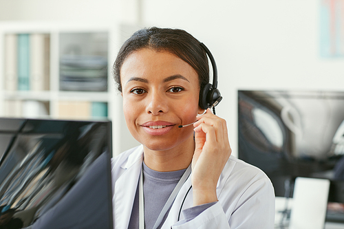 Portrait of African young woman in headphone sitting in front of computer she working in an ambulance