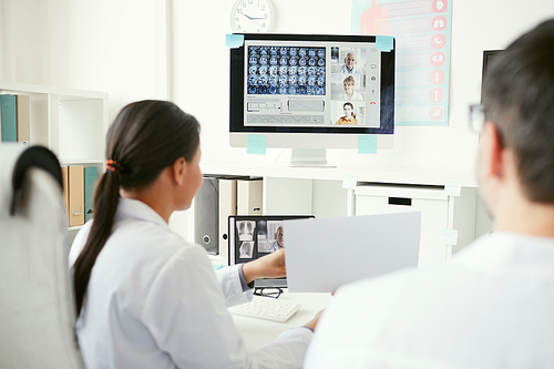 Group of doctors on computer monitor discussing x-ray images with colleagues during online conference