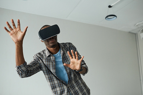 African young man wearing VR goggles he playing in virtual reality game