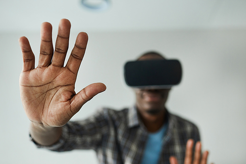 African man in glasses gesturing while playing in virtual reality game