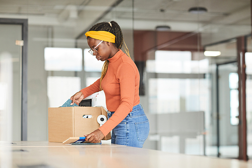 African young woman unpacking the box with stuffs she getting a new job at office