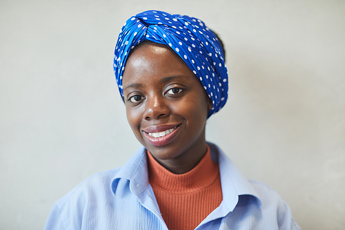 Portrait of African young woman with beautiful scarf on her head smiling at camera