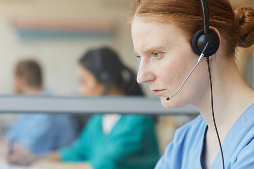 Close-up of female operator in headphones concentrating on her work in call center