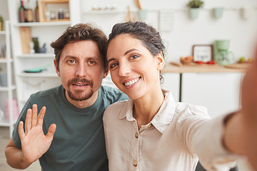 Portrait of young couple smiling at camera they making selfie at home