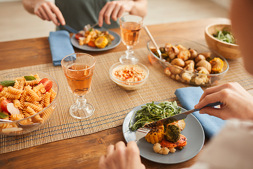 Close-up of couple eating healthy dinner and drinking wine at the table at home
