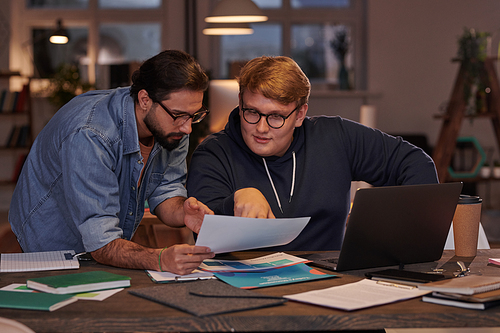 Two businessmen sitting at the table and discussing business documents in team working at office