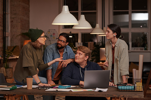 Business people in casual clothing discussing together online presentation on laptop working in team