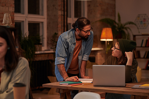 Businessman discussing work with businesswoman during working day at office