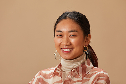 Close-up of Asian pretty girl smiling at camera isolated on beige background