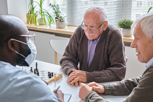 Elderly man listening the recommendation of doctor during their conversation at the table