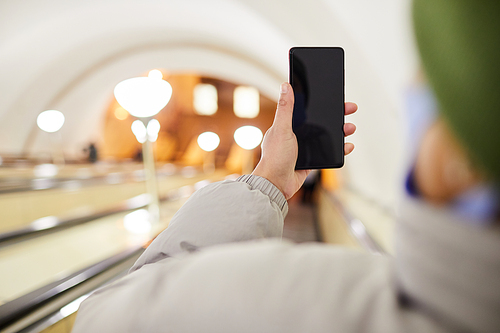 Close-up of woman holding mobile phone while making photo of underground