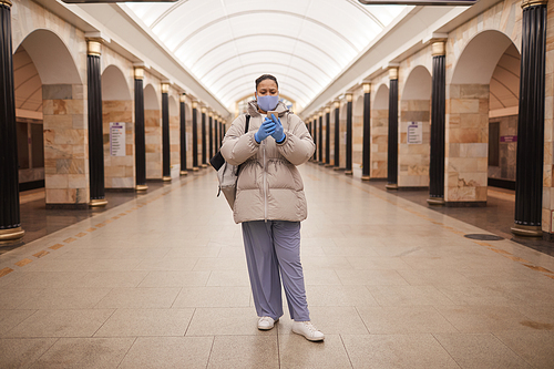 Portrait of woman in warm clothing making selfie on her mobile phone while standing in subway