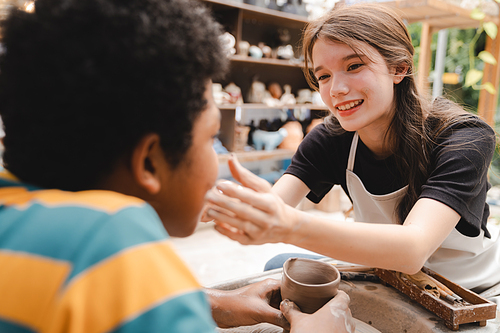 happy smiling girl having fun to learning and work with craft art of clay hand-made workshop in ceramic studio, little ceramist enjoy in creative handcraft hobby with pottery artisan school class