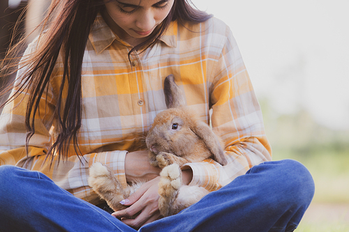 relationships of cheerful rabbit and happy young human girl, Asian woman holding and carrying cute rabbit with tenderness and love. Friendship with cute easter bunny. Happy of Easter's Day