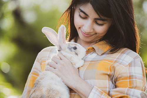 relationships of cheerful rabbit and happy young human girl, Asian woman holding and carrying cute rabbit with tenderness and love. Friendship with cute easter bunny. Happy of Easter's Day