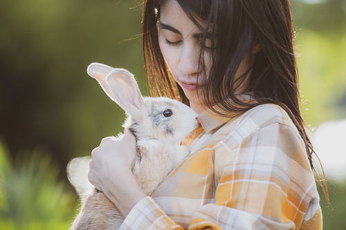 relationships of cheerful rabbit and happy young human girl, Asian woman holding and carrying cute rabbit with tenderness and love. Friendship with cute easter bunny. Happy of Easter's Day