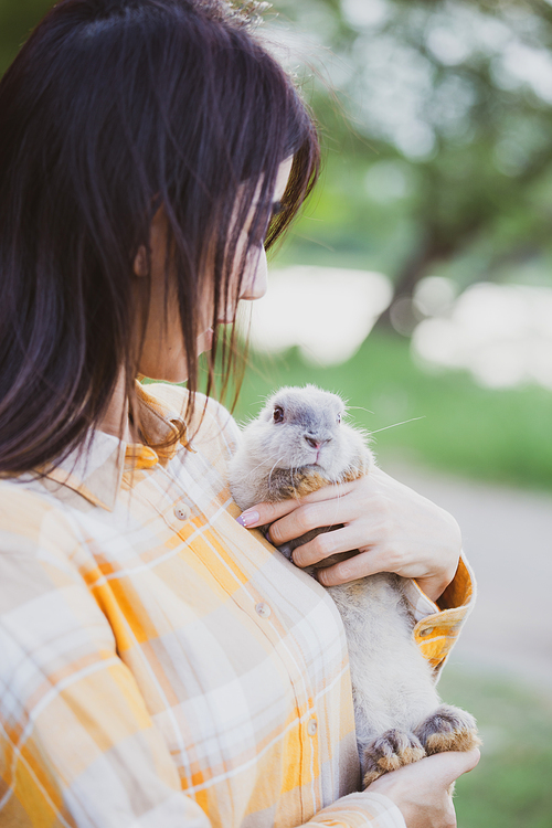 relationships of cheerful rabbit and happy young human girl, Asian woman holding and carrying cute rabbit with tenderness and love. Friendship with cute easter bunny. Happy of Easter's Day