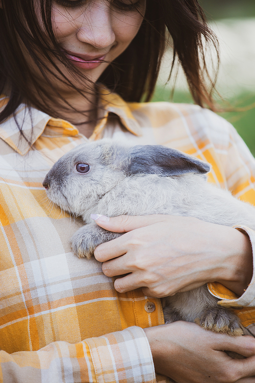 relationships of cheerful rabbit and happy young human girl, Asian woman holding and carrying cute rabbit with tenderness and love. Friendship with cute easter bunny. Happy of Easter's Day