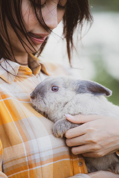 relationships of cheerful rabbit and happy young human girl, Asian woman holding and carrying cute rabbit with tenderness and love. Friendship with cute easter bunny. Happy of Easter's Day