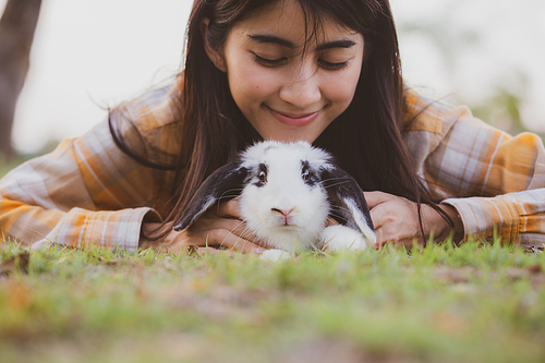 relationships of cheerful rabbit and happy young human girl, domestic friendship family of little cute easter pet and friends person having smile and fun, animal love and care at home concept