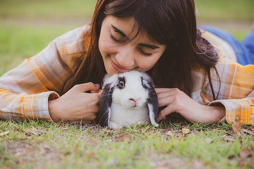 relationships of cheerful rabbit and happy young human girl, domestic friendship family of little cute easter pet and friends person having smile and fun, animal love and care at home concept