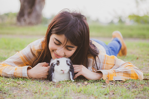 relationships of cheerful rabbit and happy young human girl, domestic friendship family of little cute easter pet and friends person having smile and fun, animal love and care at home concept