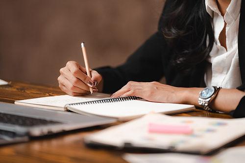 Asian businesswoman reviewing document reports and Signing Contract at office workplace with computer laptop. legal expert, professional lawyer reading and checking financial documents or insurance