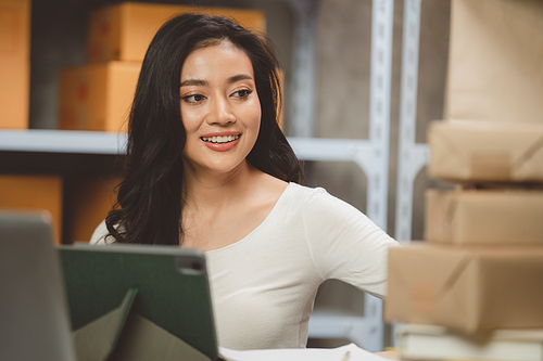 Young woman working at home for packeting parcel box to shipping delivery service to customer, online business marketing concept