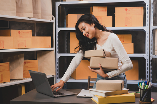 woman entrepreneur's hand holding package of parcel box, Preparing pack delivery packet product for selling online of home shipping service, Startup with small business marketing concept