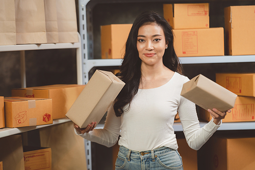 young beautiful woman smiling and happy with thumbs up handle the parcel. Young women packing a parcel order for shipping service to online customer.