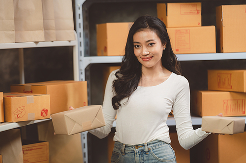 woman entrepreneur's hand holding package of parcel box, Preparing pack delivery packet product for selling online of home shipping service, Startup with small business marketing concept