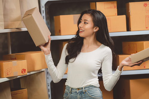 woman entrepreneur's hand holding package of parcel box, Preparing pack delivery packet product for selling online of home shipping service, Startup with small business marketing concept