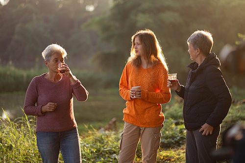 female family in holiday with hot drink of coffee or tea, young woman person in vacation tent camping lifestyle with nature to adventure mountain hiking travel, happy together with morning drink