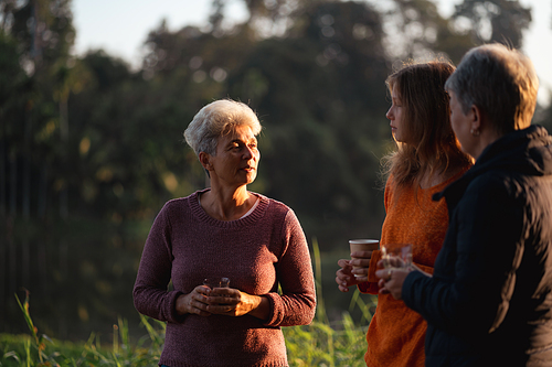 family of senior woman and teenager talking about activity recreation and picnic while coffee breakfast together in morning weekend, camping travel vacations trip in holiday, outdoor leisure party