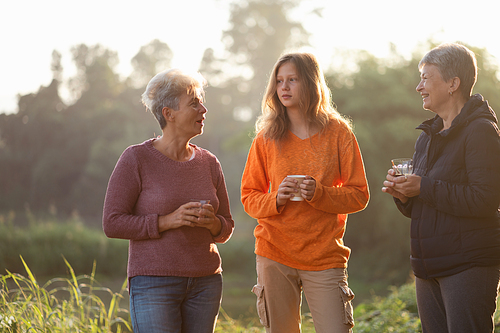 family of senior woman and teenager talking about activity recreation and picnic while coffee breakfast together in morning weekend, camping travel vacations trip in holiday, outdoor leisure party