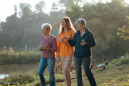 female family in holiday with hot drink of coffee or tea, young woman person in vacation tent camping lifestyle with nature to adventure mountain hiking travel, happy together with morning drink