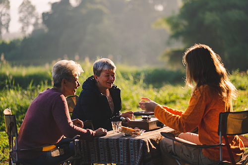 female family in holiday with hot drink of coffee or tea, young woman person in vacation tent camping lifestyle with nature to adventure mountain hiking travel, happy together with morning drink