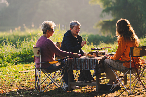 female family in holiday with hot drink of coffee or tea, young woman person in vacation tent camping lifestyle with nature to adventure mountain hiking travel, happy together with morning drink