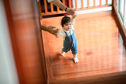 father help children baby to walk, childhood family people with little cute toddler child son, happy learning in first step with support together from father at home