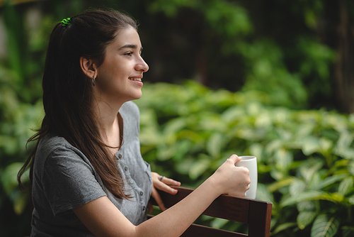 young beautiful woman person are happy and enjoy with coffee drink in the morning at home, relax lifestyle by holding coffee or tea cup at nature outdoor park, smile pretty girl with freedom time