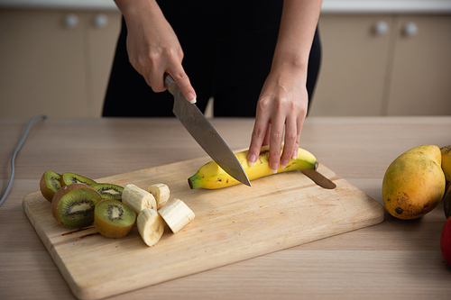 young Asian woman cooking vegetable healthy food and eating or drinking in home kitchen