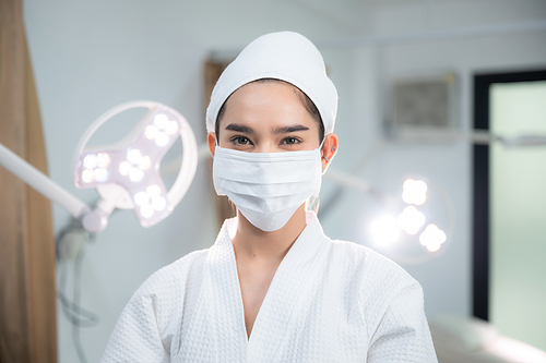 young Asian woman making treatment cosmetic beauty therapy on a face at cosmetological clinic