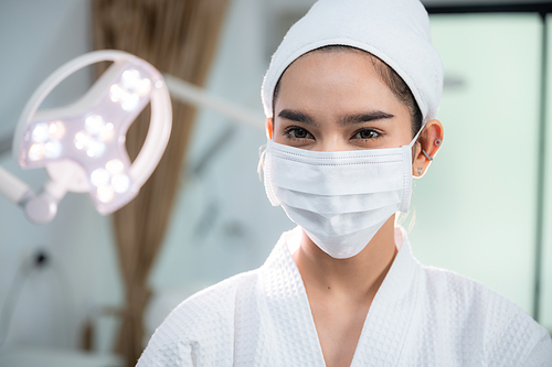 young Asian woman making treatment cosmetic beauty therapy on a face at cosmetological clinic