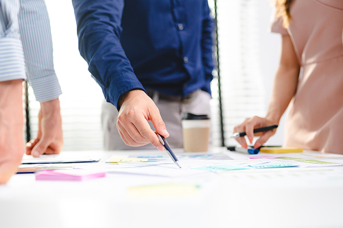 Employee business man give flip chart presentation to smiling colleagues at negotiations, workers laugh at office meeting, man present project or idea to happy coworkers at briefing