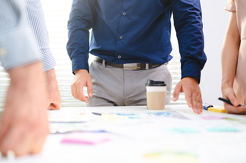 Employee business man give flip chart presentation to smiling colleagues at negotiations, workers laugh at office meeting, man present project or idea to happy coworkers at briefing